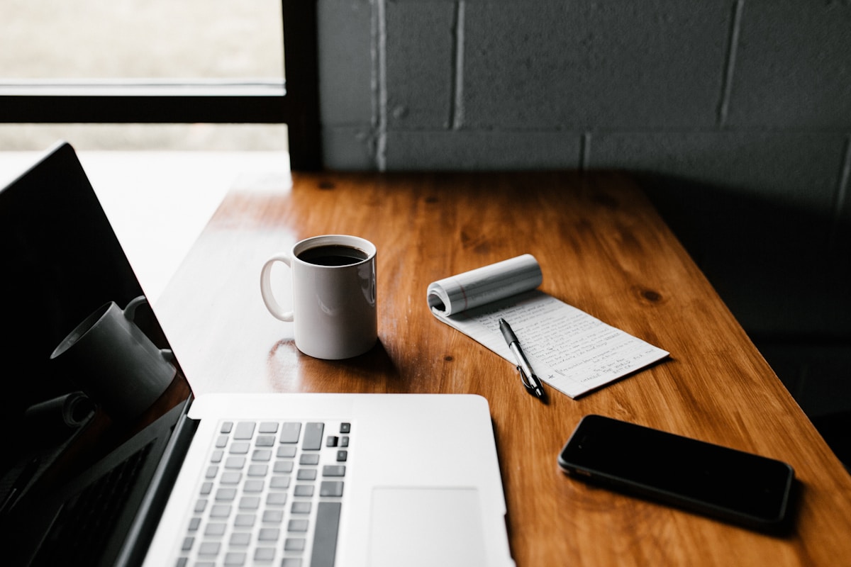 Desk with laptop and notebook for starting a blog from scratch
